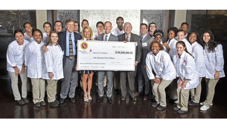 Southern Glazer's CEO Wayne E. Chaplin awarding large check to students.